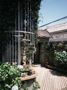 a porch of a house with plants and flowers at Dali GuGu Hotel in Dali Ancient Town