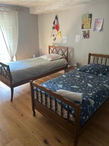a bedroom with two beds and a window at Double chambres hôtes parentales in Damvix