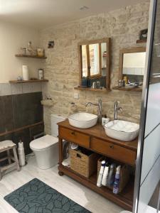 a bathroom with two sinks and a toilet at Double chambres hôtes parentales in Damvix +24 photos