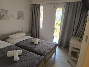 a hotel room with two beds and a window at Renia Studios - Pool & Beach in 150m - Agia Pelagia in Agia Pelagia +94 photos