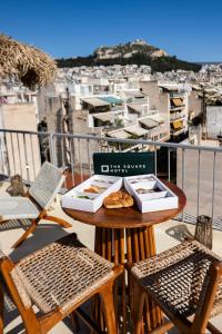 a table with two boxes of food on a balcony at The Square Hotel by X&N in Athens