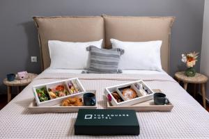 a bed with two trays of food on it at The Square Hotel by X&N in Athens