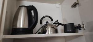 a kitchen shelf with a tea kettle and cups at Nino in Kaspi +22 photos