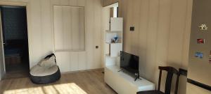 a living room with a television and a couch at Nino in Kaspi