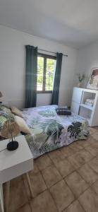 a bedroom with a bed with a colorful comforter at Maison T3 Bastia Sud, Casamozza in Monte