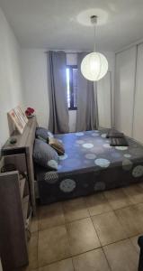 a bedroom with a bed and a table and a window at Maison T3 Bastia Sud, Casamozza in Monte