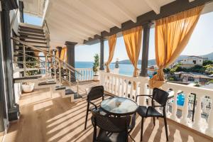 a balcony with a table and chairs and the ocean at Qeparo Napolon Complex in Qeparo