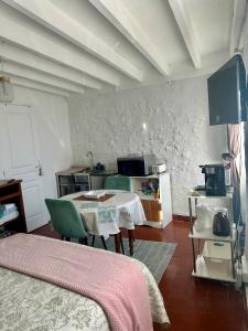 a room with a table and a kitchen with a tv at La Maisonnette in Cellettes