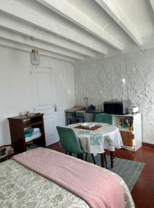a room with a table and a kitchen with a table and chairs at La Maisonnette in Cellettes