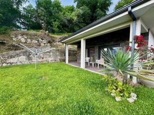 a house with a grass yard with a building at Casa do Alambique in Alvaredo