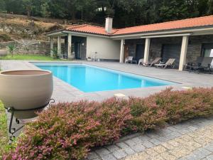 a swimming pool in front of a house at Casa do Alambique in Alvaredo