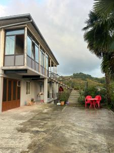 a house with red tables and chairs in front of it at Davitis Vila in Chakvi