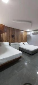 a room with two beds and a wall with wood at Hyton Grand - Kilambakkam in Urapakkam