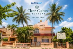 a house with palm trees in front of it at Clean Culture Retreat in Mysore