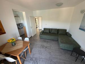a living room with a green couch and a table at Nela Apartment in Rabac
