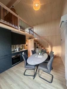 a dining room with a table and chairs and a staircase at Die Tinys - Ferienhäuser am Attersee in Nussdorf am Attersee