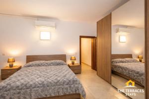a hotel room with two beds and a mirror at The Terraces Seafront Getaway Malta 3 Bedroom Apartment in St. Paul's Bay