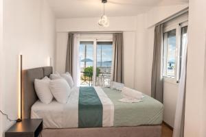 a bedroom with a bed with a view of the ocean at Pelagos Suites in Igoumenitsa