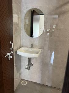 a bathroom with a sink and a mirror at DownTown INN in Manendragarh