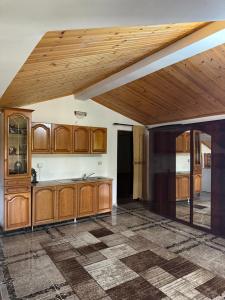 a kitchen with wooden cabinets and a wooden ceiling at Villa Velipoj in Velipojë