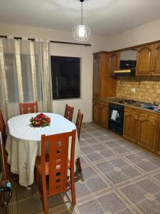 a kitchen with a table with a flower arrangement on it at Villa Velipoj in Velipojë +11 photos