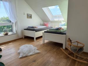 a attic room with two beds and a window at Ferienwohnung Anemone - 4 Zimmer mit Bergblick & Alpenflair in Germaringen +36 photos