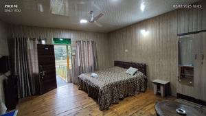 a bedroom with a bed in a room with wooden floors at Nalari Resort in Borpāni