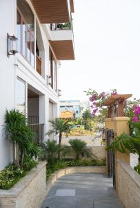 a walkway in front of a building with plants at Lúa Boutique Hoi An Hotel in Tân Thành (1)