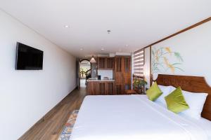 a bedroom with a large bed and a television at Lúa Boutique Hoi An Hotel in Tân Thành (1)