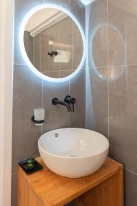 a bathroom with a white sink and a mirror at Pelagos Suites in Igoumenitsa +175 photos