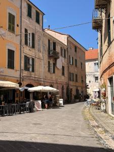 an empty street with tables and umbrellas and buildings at Casa Meloria in Finale Ligure