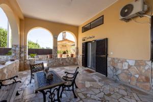 a patio with a table and chairs and a tv at Sweet Nonna Dora Corato - Casa con Parcheggio in Corato