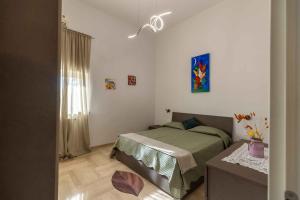 a bedroom with a bed and a table in it at Sweet Nonna Dora Corato - Casa con Parcheggio in Corato