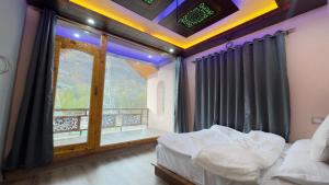a bedroom with a bed and a balcony with a window at Pahadon Ka Ghar in Sonāmarg +29 photos