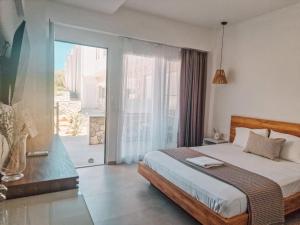 a bedroom with a bed and a sliding glass door at My Place modern living in Kefalos +37 photos