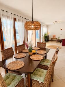 a dining room with a table with wicker chairs at SPLENDID Sunset Penthouse in Rafailovici