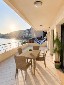 a table and chairs on a balcony with a view of the ocean at SPLENDID Sunset Penthouse in Rafailovici