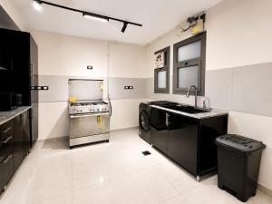 a kitchen with a stove and a sink and a dishwasher at Cyra gate Suncapital compound شقة في كامبواند صنكابيتال بوابة كايرا بالقرب in ‘Ezbet `Abd el-Ḥamîd