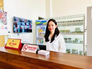 a woman sitting at a counter in a pharmacy at Khách sạn Cao Sơn in Cửa Ông