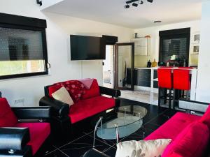 a living room with red furniture and a red couch at Lux apartmani in Bihać