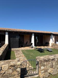a house with a stone wall in front of it at Villino Giò - Residence Abba Urci in Tertenìa