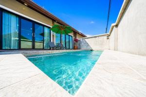 a swimming pool with a green umbrella next to a building at Arterra Haven , Aonang Krabi in Ao Nang Beach +43 photos