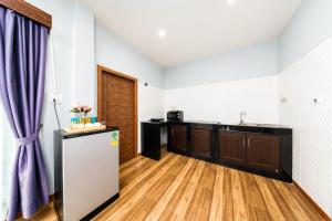a kitchen with a refrigerator and wooden floors at Arterra Haven , Aonang Krabi in Ao Nang Beach