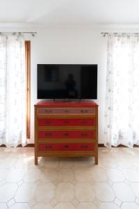 a tv on top of a dresser in a room at Enza House in Chioggia