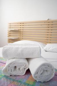 a bed with white blankets and pillows on it at Enza House in Chioggia