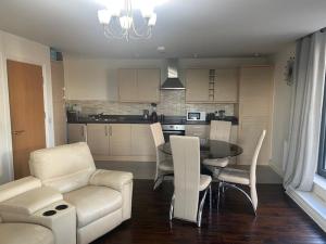 a living room with a table and chairs and a kitchen at Colindale Central Apartment in Colindale