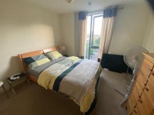 a bedroom with a bed and a window at Colindale Central Apartment in Colindale