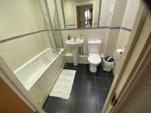 a bathroom with a sink and a toilet and a bath tub at Colindale Central Apartment in Colindale +6 photos