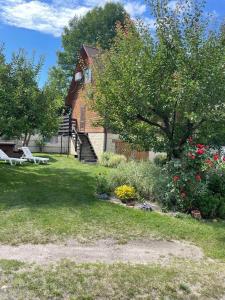 a yard with a house with a bench and flowers at Затишок in Svityazʼ