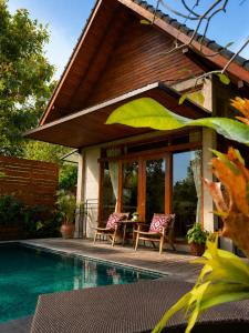 a patio with a table and chairs next to a pool at LUV-Balian in Balian